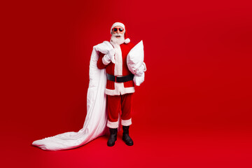 Santa Claus in festive costume with white blanket on red background celebrating christmas holidays...