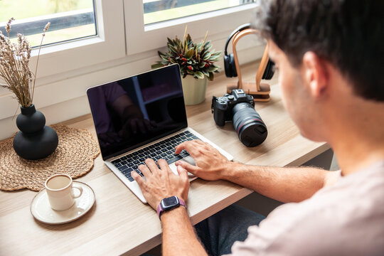 Young Hispanic man teleworking from home using laptop