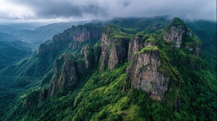 Majestic Mountain Peaks Surrounded by Lush Green Forests and Dramatic Clouds in Nature