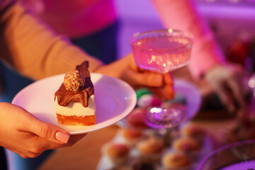 People with drinks and delicious desserts at buffet table, selective focus