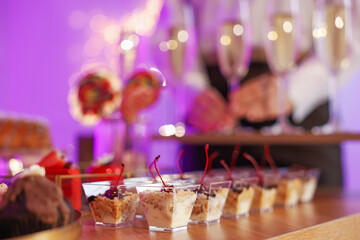 Different delicious desserts on buffet table and waiter, selective focus