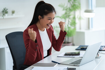 Professional woman looking excited after reading email on laptop