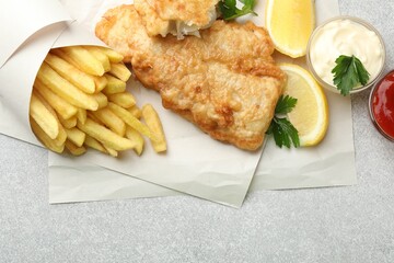 British Traditional Fish and chips served with sauces on light grey table, flat lay. Space for text