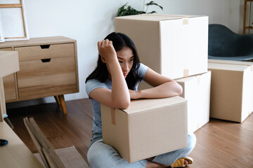 Woman stressed and tired packing boxes for relocation to new house