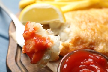 Eating British Traditional Fish and chips with sauce at table, closeup