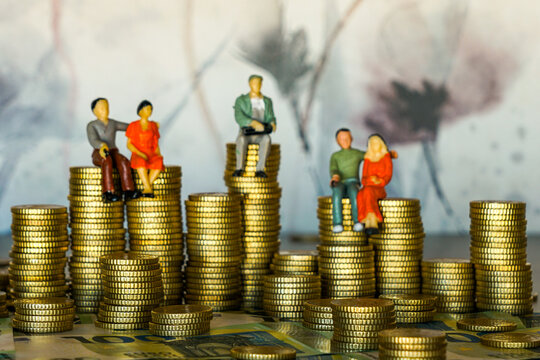 Miniature figurines sitting on euro coin stacks symbolizing wealth, savings, and financial planning - Powered by Adobe