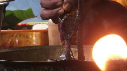 Close-up of Shivling pooja with milk, flowers, and bael leaves being offered. Indian people performing sacred havan on the occasion of Mahashivratri, offering gheeFocused on Background.
