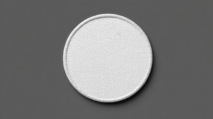 White circular fabric patch with textured surface on gray background