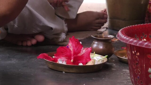 Close-up of Shivling pooja with milk, flowers, and bael leaves being offered. Indian people performing sacred havan on the occasion of Mahashivratri, offering ghee to the holy fire during  Vedic puja.