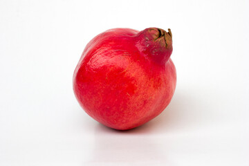 A vibrant red pomegranate fruit isolated on white background. Research suggests pomegranate's antioxidants may help slow cancer cell growth and reduce the risk of certain cancers.