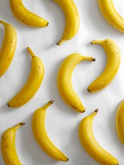 A minimalist pattern of yellow bananas arranged in simple lines on a white background viewed from directly above