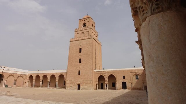 Revealing gimbal shot of tower and courtyard of the Great Mosque of Kairouan, historic landmark and place of important worship for Muslims in Tunisia Africa