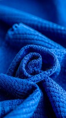 Intricate close-up of tightly curled, textured, vibrant blue fabric