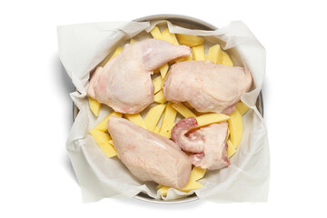 raw chicken with potatoes in tray