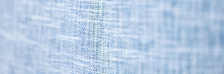 Close-up view of blue textured fabric with abstract pattern displaying fine fibers in soft focus.