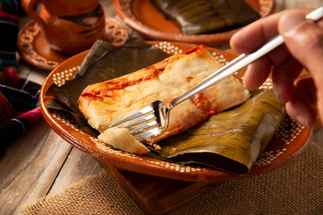 Oaxacan Tamales. A pre-Hispanic dish typical of Mexico and some Latin American countries. Corn dough wrapped in banana leaves is filled with meat or a stew. Tamales are steamed.
