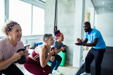 Senior women exercising with trainer