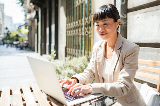 Businesswoman working on laptop outdoors