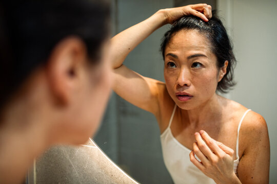 Woman looking in mirror in a bathroom