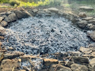 Campfire Remains in Stone Circle – Ash and Burned Wood at Dusk or Dawn