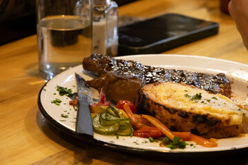 Veal steak topped with cheese and accompanied by vegetables looks delicious
