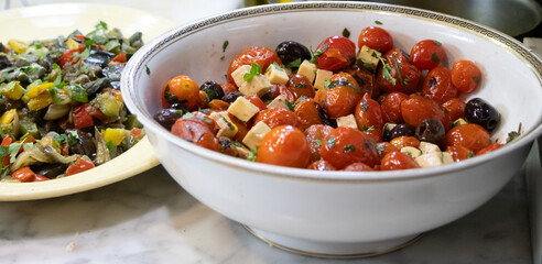 Bowl of Mediterranean salad made with cherry tomatoes, black olives, and cubed cheese