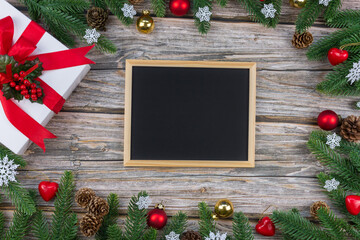 Christmas and New Year frame on wooden background with chalkboard, festive decorations and copy space