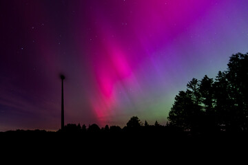 Leuchtende Nordlichter. Gr&uuml;n-violette Aurora Borealis tanzt &uuml;ber Landschaft und Himmel.