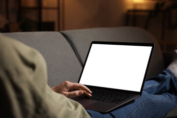 Woman working with laptop on sofa indoors, closeup. Mockup for design