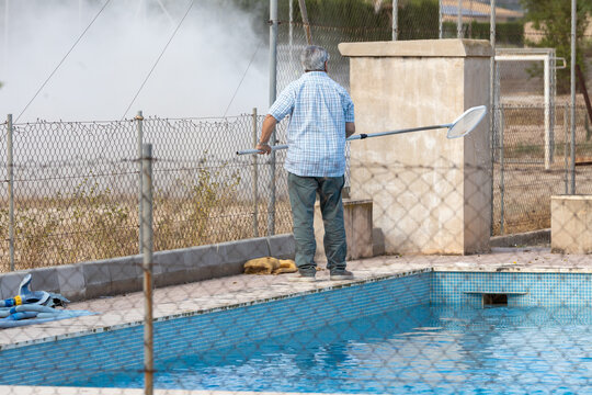 Man cleaning the pool water.