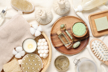 Flat lay composition with spa essentials on light fabric