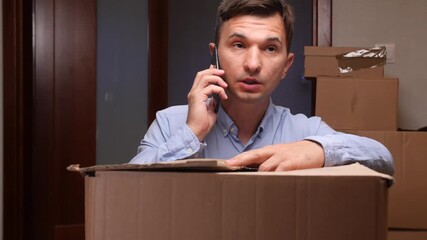 Stressed man talking on phone during home relocation