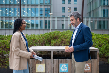 Diverse colleagues recycling plastic water bottle and coffee cup