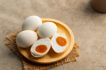 Salted eggs in wooden plate.a preserved food, traditionally made by curing duck or chicken eggs in brine.popular delicacy in many Asian cuisines.
