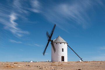 A windmill in La Mancha, isolated on land in Campo de Criptana, Ciudad Real province, Spain.