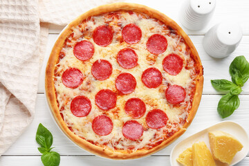 Delicious pepperoni pizza and ingredients on white wooden table, flat lay