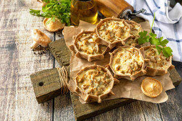 Rustic mushroom tartlets on wooden cutting board perfect for  appetizers.  Copy space.