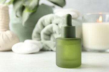 Beautiful composition with spa products and burning candle on white table, closeup. Space for text