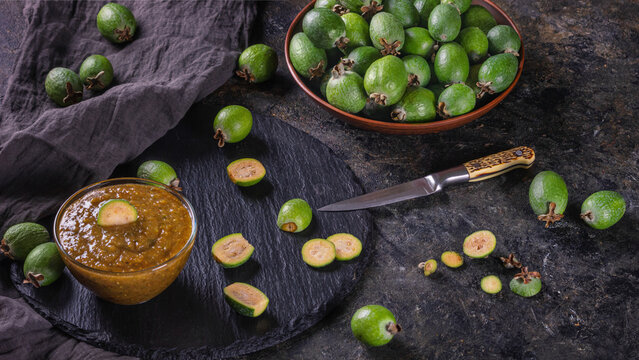 Tropical fruits green ripe feijoa sellowiana berries and jam from it. Still life with sliced feijoa fruits