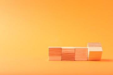 Blank wooden cubes on orange background, space for text