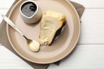 Piece of delicious Basque cheesecake and chocolate sauce on white wooden table, top view. Space for text