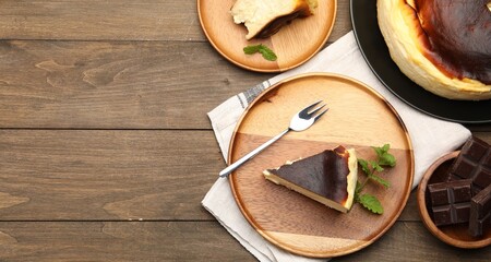 Delicious Basque cheesecake with mint and chocolate on wooden table, flat lay. Space for text