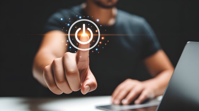 Man using laptop with pressing power button on virtual screen. Start or shut down concept.