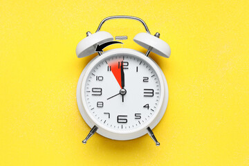 Alarm clock on yellow background, closeup