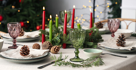 Festive table setting with Christmas decorations, burning candles and pine cones in dining room, closeup