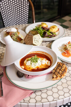 brunch at a moroccan theme restaurant with fusion shakshuka, eggs benedict, salad, and bread
