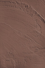 Close up, macro of vibrant brown colored cement wall surface with rough, heavily textured, and abstract plaster strokes. Grunge background, industrial backdrop, modern wallpaper, design element.