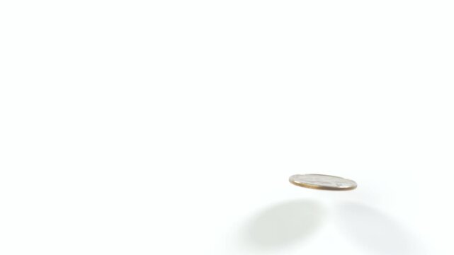 A United States quarter dollar bounces on a perfectly white surface. Slow Motion.