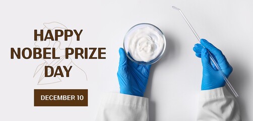 Scientist's hands holding Petri dish with sample on white background. Nobel Prize Day