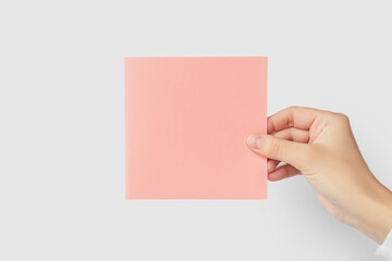 Hand holding blank pink square card